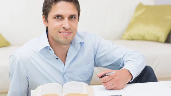 Retrato de um homem com caneta e livro em casa — Fotografia de Stock