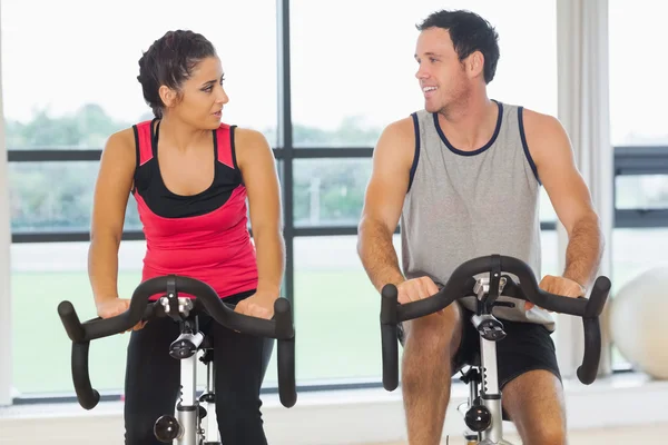 Young man and woman working out at spinning class — Stock Photo, Image