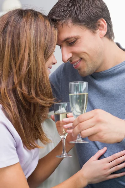 Romántico sonriente joven pareja tostando flautas en casa —  Fotos de Stock