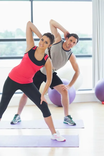 Portret van twee sportieve mensen handen uitrekken op yoga klas — Stockfoto