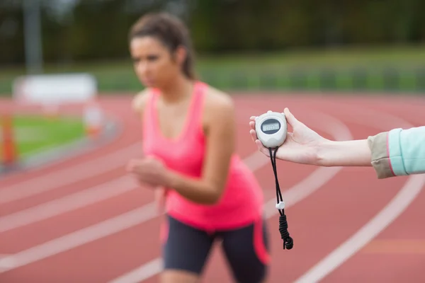 Hand timing en kvinna kör på löparbanan — Stockfoto
