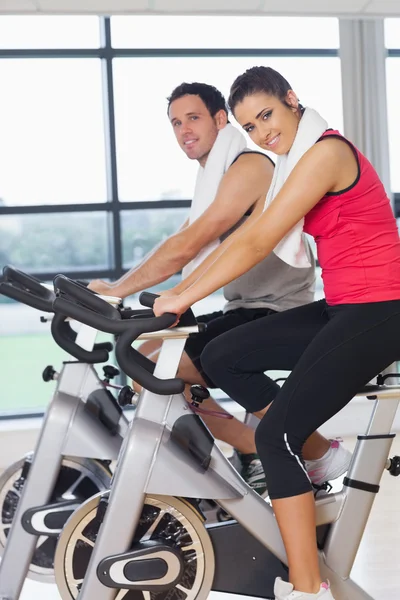 Joven hombre y mujer haciendo ejercicio en la clase de spinning —  Fotos de Stock