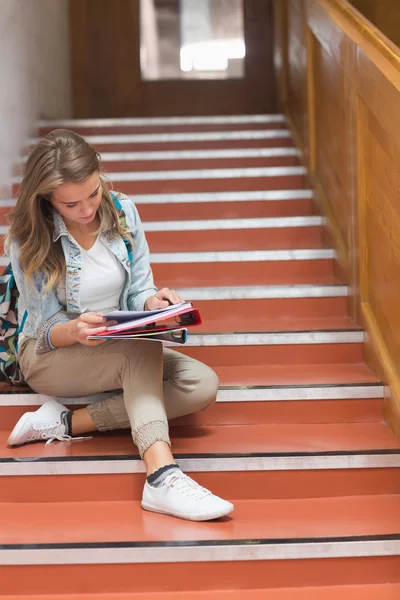 Pretty young student sitting on stairs looking at camera — Stock Photo, Image