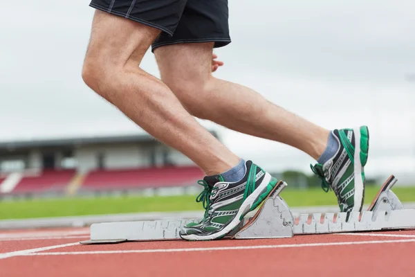 Lage sectie van een man klaar om te racen op de looppiste — Stockfoto