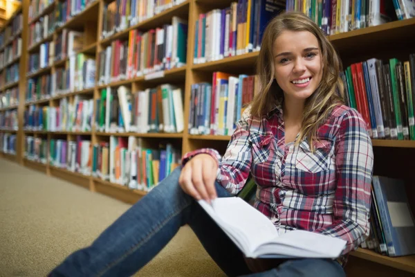 Jovem estudante bonita sentado na biblioteca livro de leitura chão — Fotografia de Stock