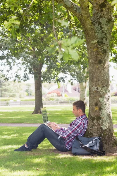 Jonge student met behulp van zijn laptop buiten — Stockfoto