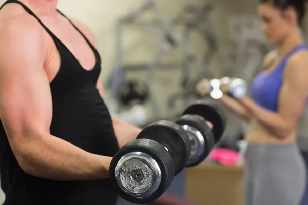 Mid section of a shirtless man and woman with dumbbells — Stock Photo, Image