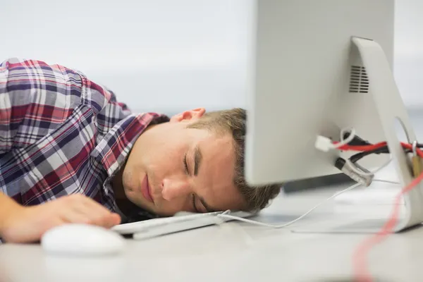 Handsome student dozing in the computer room — Stock Photo, Image