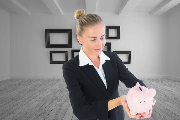 Composite image of businesswoman holding piggy bank — Stock Photo, Image