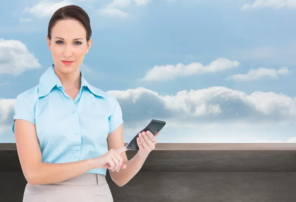 Composite image of serious classy businesswoman using calculator — Stock Photo, Image