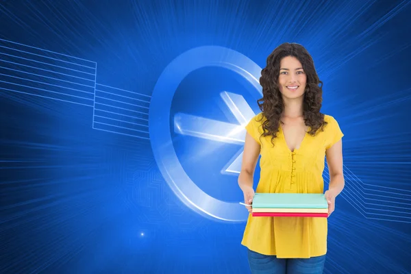 Smiling curly haired brunette holding notebooks — Stock Photo, Image