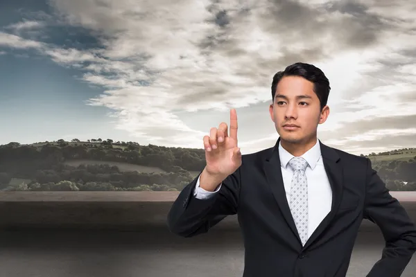 Composite image of unsmiling asian businessman pointing — Stock Photo, Image