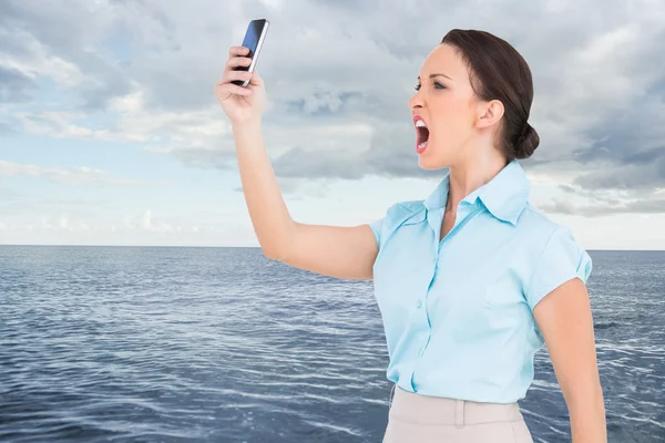 Bild einer wütenden Geschäftsfrau, die ihr Smartphone anbrüllt — Stockfoto