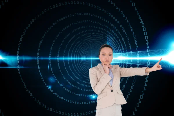Composite image of thoughtful asian businesswoman pointing — Stock Photo, Image