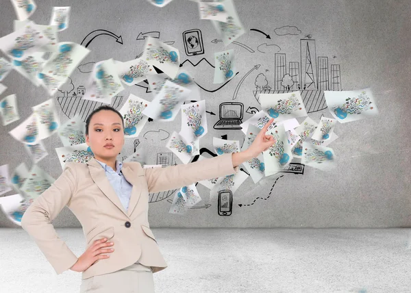 Composite image of unsmiling asian businesswoman pointing — Stock Photo, Image