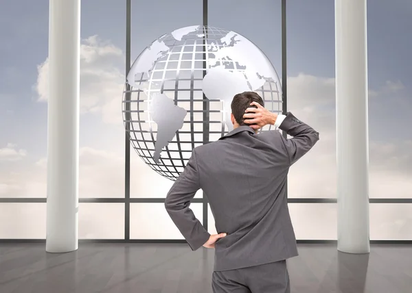 Composite image of young businessman standing back to camera — Stock Photo, Image