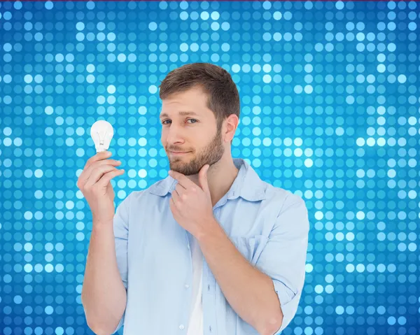 Handsome model holding a bulb — Stockfoto