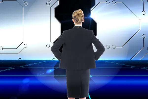 Composite image of businesswoman standing with hands on hips — Stock Photo, Image