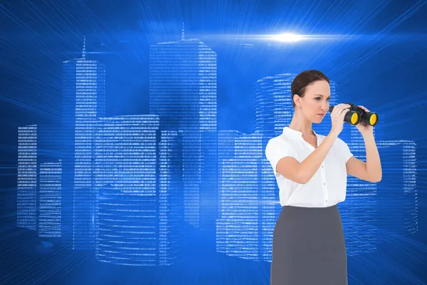 Serious elegant businesswoman looking through binoculars — Stock Photo, Image