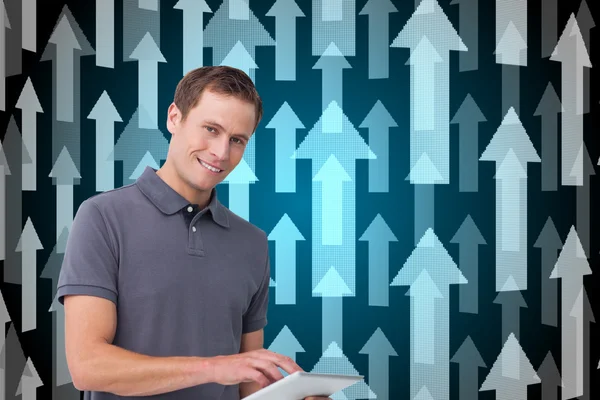 Composite image of smiling young man with tablet computer — Stock Photo, Image