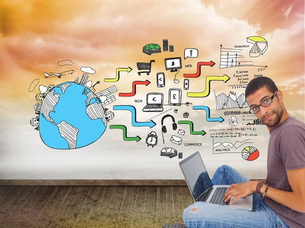 Man wearing glasses sitting on floor using laptop — Stock Photo, Image