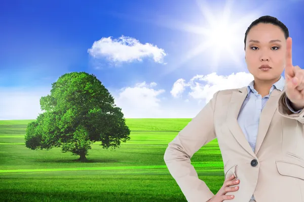 Composite image of unsmiling asian businesswoman pointing — Stock Photo, Image