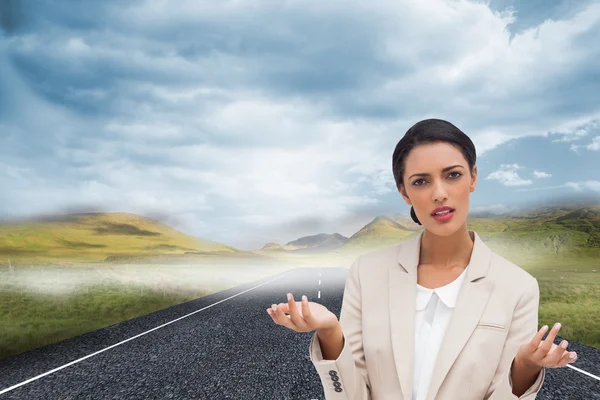 Composite image of confused businesswoman standing — Stock Photo, Image