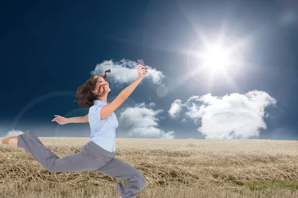 Imagen compuesta de feliz mujer de negocios con clase saltando — Foto de Stock