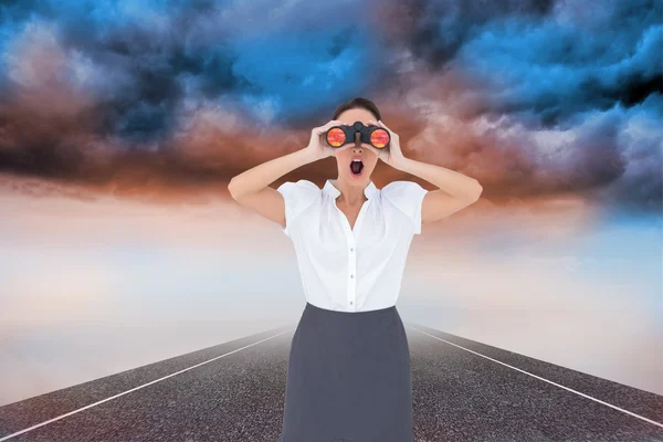 Imagen compuesta de impactada mujer de negocios elegante mirando a través de —  Fotos de Stock