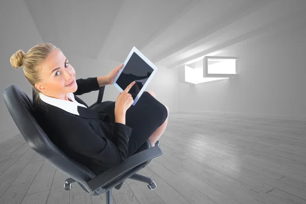 Composite image of businesswoman sitting on swivel chair with tablet — Stock Photo, Image