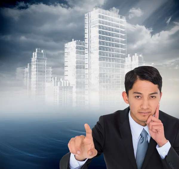 Composite image of thoughtful asian businessman pointing — Stock Photo, Image