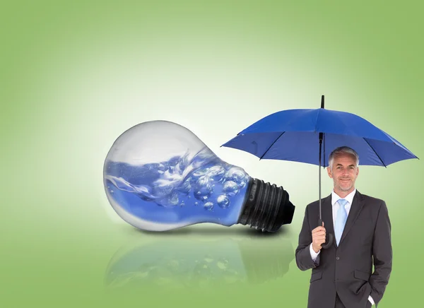 Businessman holding blue umbrella — Stock Photo, Image