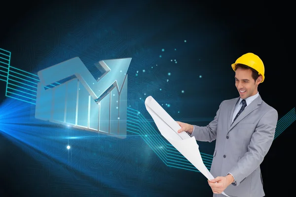 Smiling architect with hard hat looking at plans — Stock Photo, Image