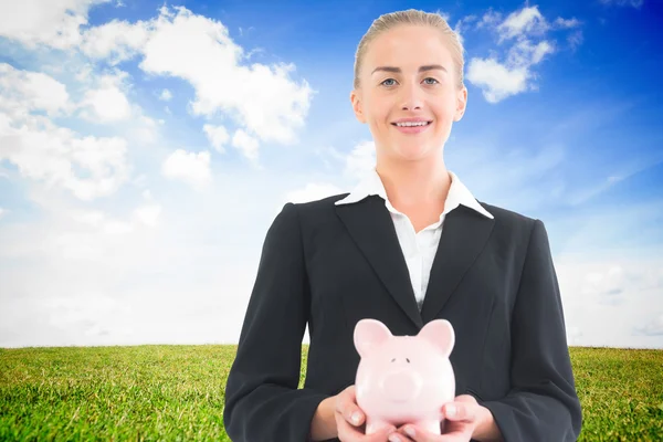 Imagem composta de empresária segurando banco porquinho — Fotografia de Stock