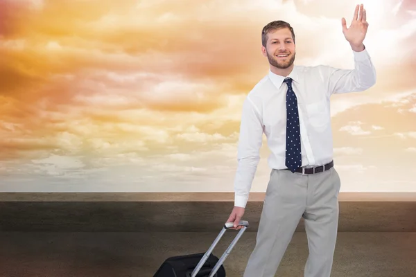 Handsome businessman with suitcase waving — Stock Photo, Image