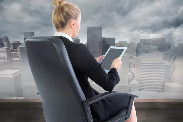 Composite image of businesswoman sitting on swivel chair with tablet — Stock Photo, Image