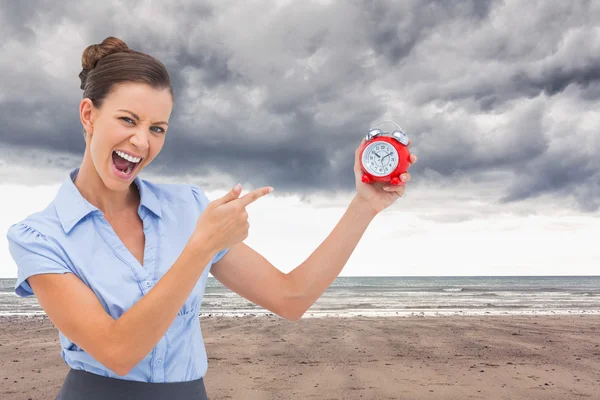 Composite image of businesswoman indicating alarm clock — Stock Photo, Image
