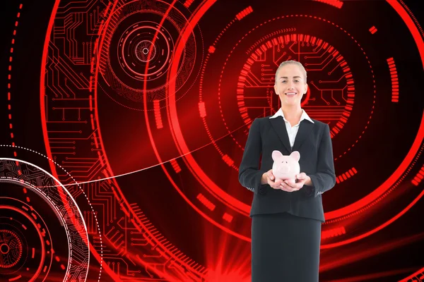 Composite image of businesswoman holding pink piggy bank — Stock Photo, Image