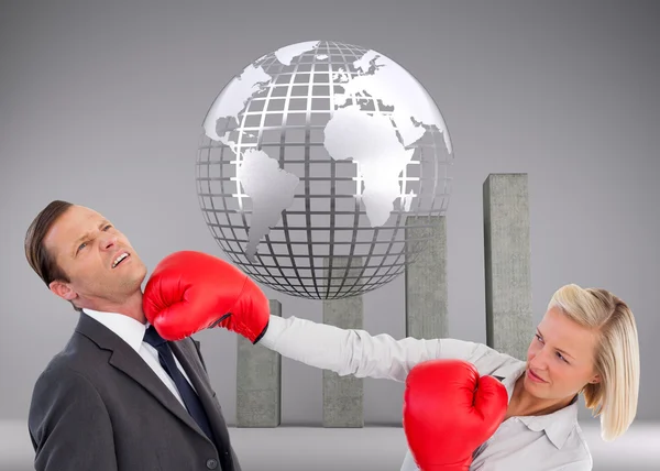 Businesswoman hitting colleague with her boxing gloves — Stock Photo, Image