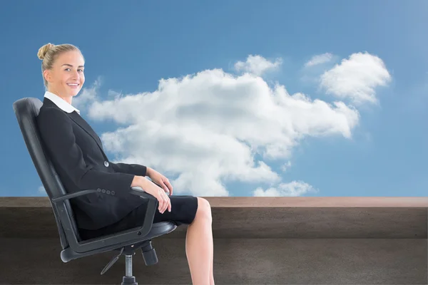 Composite image of businesswoman sitting in swivel chair — Stock Photo, Image
