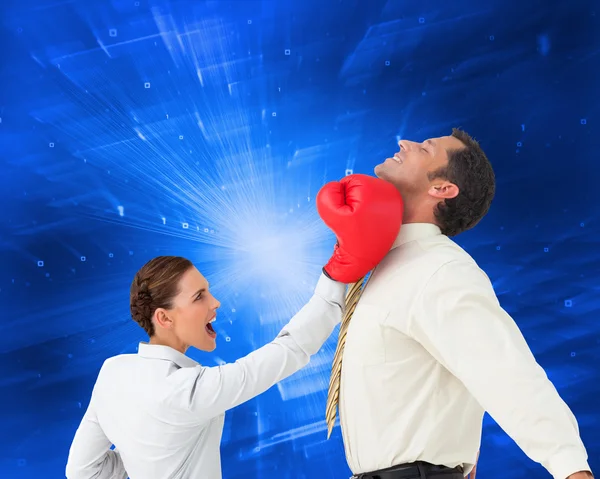 Empresaria golpeando a un empresario con guantes de boxeo — Foto de Stock