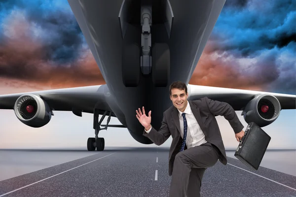 Composite image of happy businessman in a hury — Stock Photo, Image