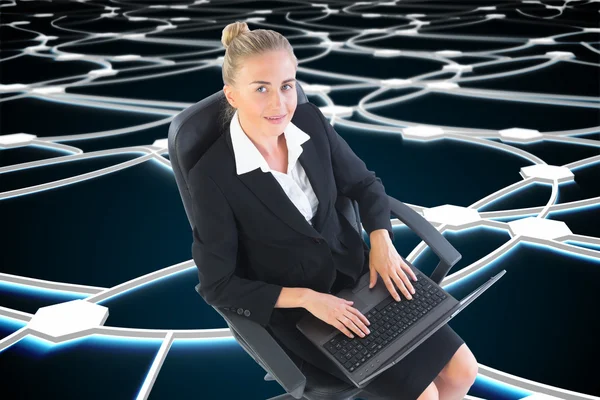Dizüstü bilgisayar ile döner sandalye üzerinde oturan iş kadını — Stok fotoğraf