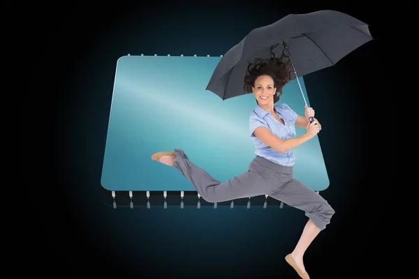 Composite image of happy classy businesswoman jumping while holding umbrella — Stock Photo, Image