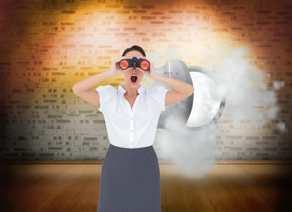 Shocked elegant businesswoman looking through binoculars — Stock Photo, Image