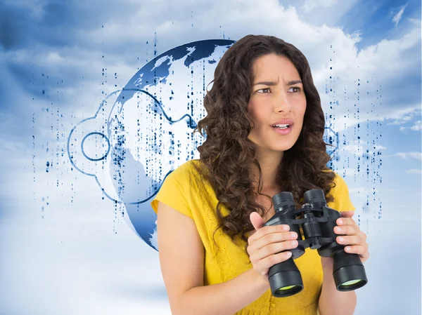 Serious casual young woman holding binoculars — Stock Photo, Image