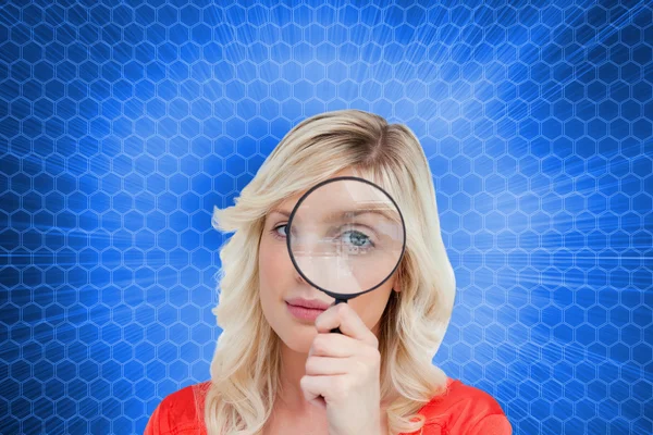 Fair-haired woman looking through a magnifying glass — Stock Photo, Image