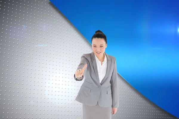 Composite image of smiling asian businesswoman pointing — Stock Photo, Image