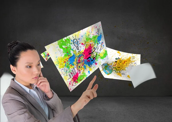 Composite image of thoughtful asian businesswoman pointing — Stock Photo, Image