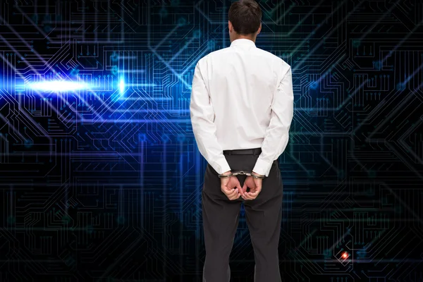 Rear view of young businessman wearing handcuffs — Stock Photo, Image